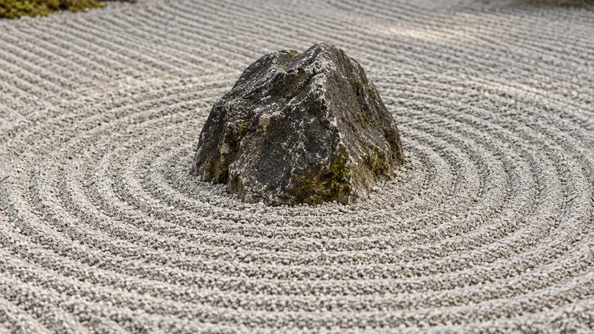 Motifs circulaires tracés dans le gravier d’un jardin zen